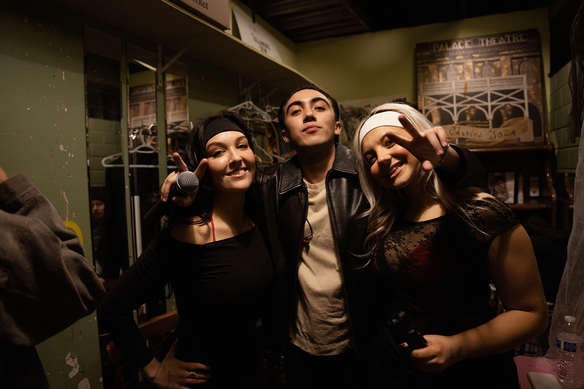 Miguel Crandell with two girls next to him holding up two fingers on each hand